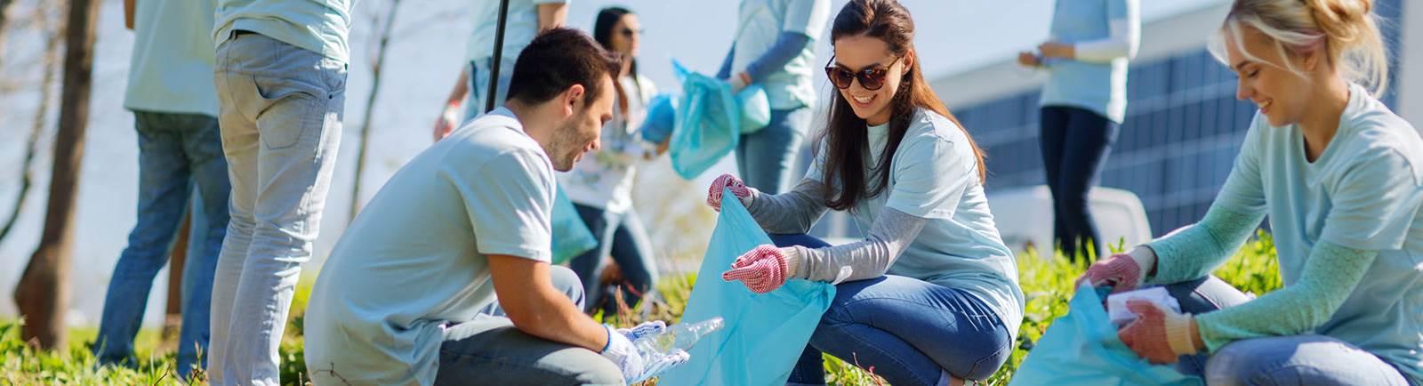 students in blue shirts cleaning litter and recycling